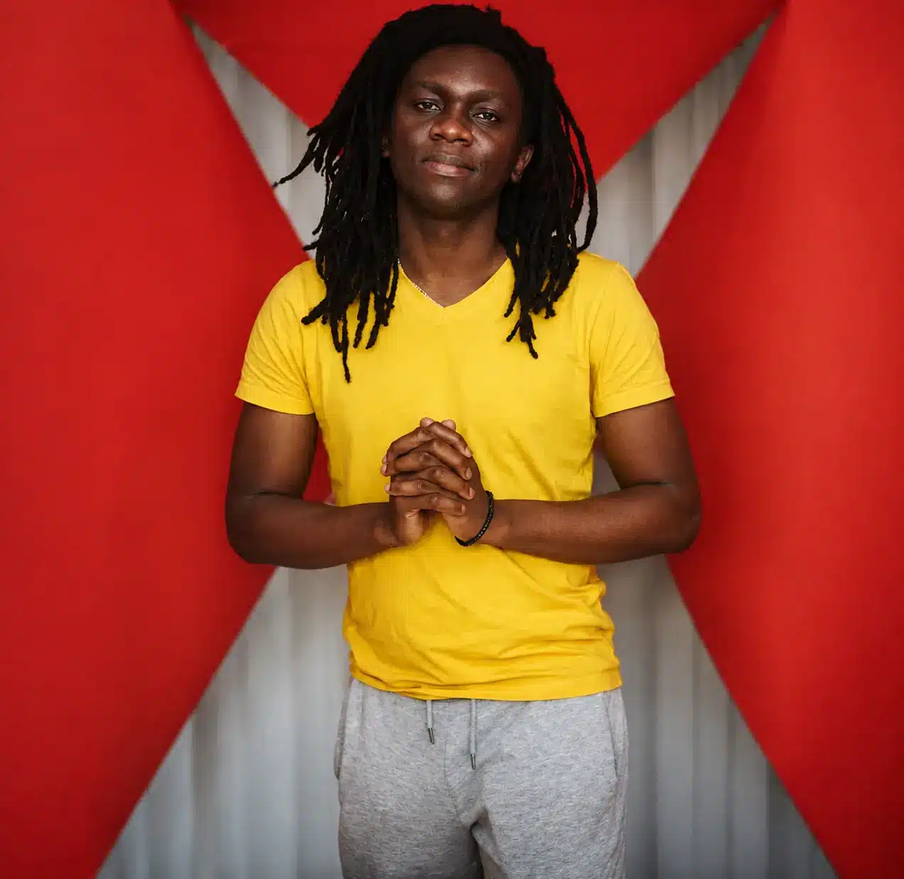 Portrait of Sonny Jermain Ndlovu, founder of Rainbow Anonymous, standing with folded arms against a white background.
